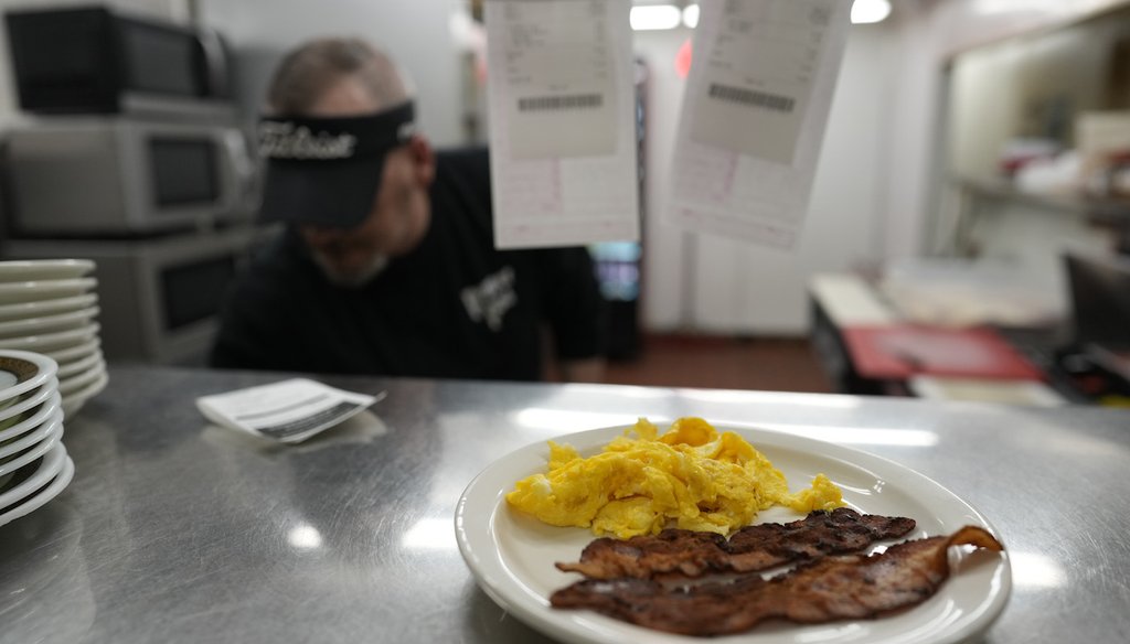 Bacon and eggs are up to serve as Chris Barton cooks at the grill at the Pepper Pod Restaurant, Feb. 13, 2025, Newport, Ky. (AP)